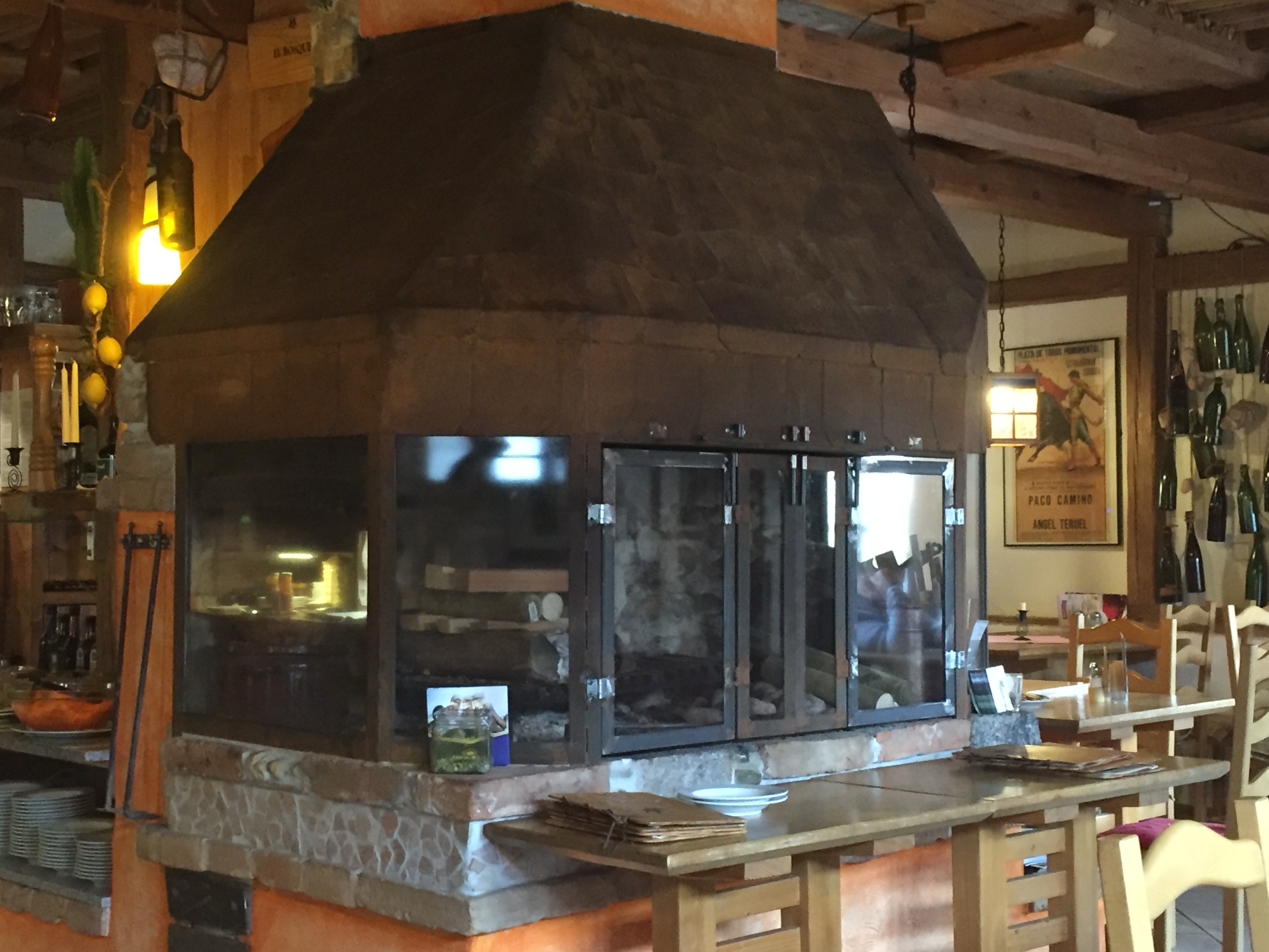 Grill-Kamin-Feuerstelle im rostigen Shabby-Schick Stil einer historischen Schmiede als rustikal gemütliches Ambiente eines Restaurants; erzeugt mit Rostlack
