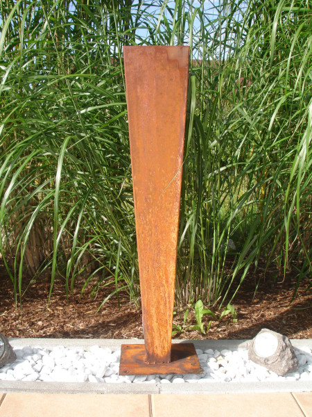 Metallsäule im Rost-Design zur Dekoration als Blickfang zwischen Ziergrassträuchern im Garten